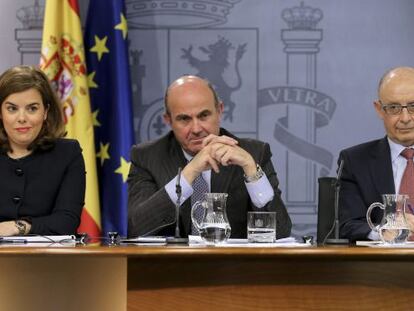 La vicepresidenta del Gobierno, Soraya Sáenz de Santamaría, junto a los ministros de Economía, Luis de Guindos; y de Hacienda, Cristóbal Montoro, durante la rueda de prensa tras la reunión semanal del Consejo de Ministros.