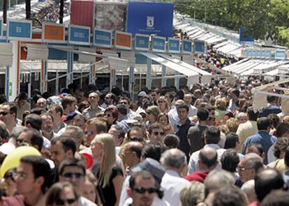 Miles de ciudadanos pasean por las casetas de la Feria del Libro de Madrid.