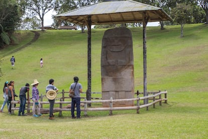 Varios visitantes observan una de las esculturas funerarias en el Parque Arqueológico de San Agustín.