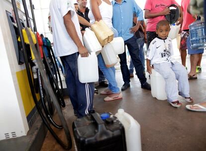 Em Luziania, pessoas fazem fila para tentar encher galões com combustíveis em um posto. Em várias cidades, postos estavam sem etanol, gasolina e diesel.