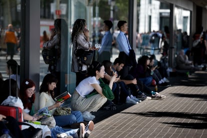 Varias personas esperan en la calle en la tarde de este lunes.