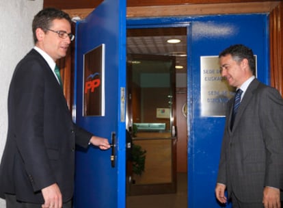 Basagoiti (izquierda) abre a Urkullu la puerta de la sede del PP en Bilbao antes del comienzo de su reunión de ayer.