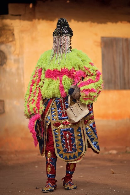 EGUNGUN (NIGERIA). La tierra de los yoruba es el lugar donde la santería cubana y el candomblé brasileño tienen sus raíces espirituales. Además de telas, para confeccionar el traje del Egungun (en la foto, uno de ellos antes del baile ritual) se emplean cuentas, madera, monedas, conchas y lentejuelas. La vestimenta se protege para preservarla de cualquier peligro o mala influencia.