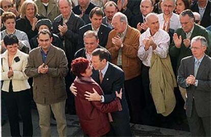 El<i> lehendakari</i> Ibarretxe abraza a María Isabel Lasa en presencia de miembros del Gobierno vasco.