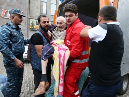 A refugee from Nagorno-Karabakh region is carried out of a vehicle upon arrival at a temporary accommodation center in the town of Goris, Armenia, September 25, 2023.