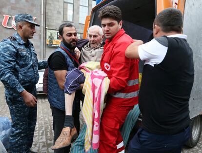 A refugee from Nagorno-Karabakh region is carried out of a vehicle upon arrival at a temporary accommodation center in the town of Goris, Armenia, September 25, 2023.