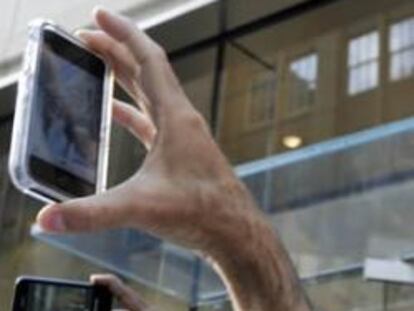 Usuarios del iPhone toman imágenes con sus móviles.