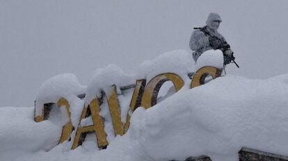 Un oficial de policía suizo armado hace guardia en el techo de un hotel cerca del bloque donde tiene lugar la reunión anual del Foro Económico Mundial en Davos (Suiza).