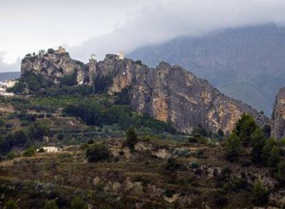 Vista de Guadalest, con la sierra de Serrella, al fondo, cubierta por las nubes.