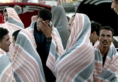 Varios inmigrantes detenidos esperan desembarcar de la patrullera de la Guardia Civil.