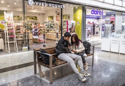 Dos jóvenes sin mascarilla en el Centro Comercial Príncipe Pío, en Madrid.