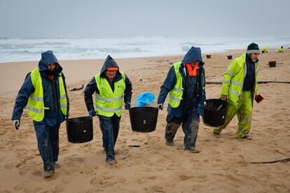 Operarios retiran pellets en una playa del Parque Natural de Corrubedo, en A Coruña, este martes.
