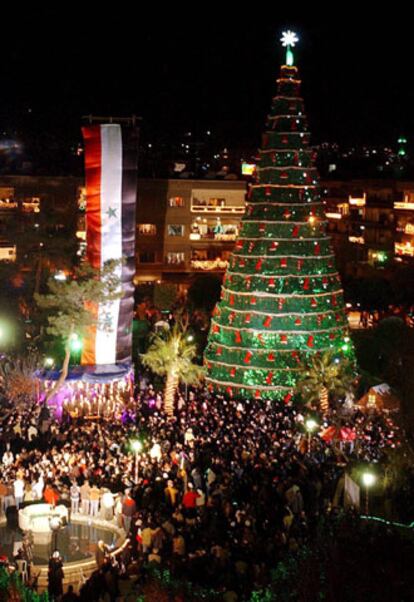 Cristianos y musulmanes asisten juntos a la iluminacin del <i>Arbol de la Paz</i> en el centro de Damasco (Siria). El abeto ha sido fabricado en acero por 700 personas, la mayora presidiarios, y est adornado con 12 millones de bombillas. Mide 27 metros de alto y doce metros y medio de ancho; y est coronado por una estrella de dos metros. La organizacin benfica musical que ha organizado esta actividad asegura que ste es el rbol de Navidad ms grande de los pases rabes.