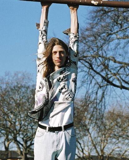 Ben viste camisa estampada y vaquero Versace. El cinturón es Hermès. Los modelos posan en las inmediaciones de London Fields, un rincón verde al que acuden con el buen tiempo los vecinos del barrio de Dalston y, en general, los de todo Londres. ¿El motivo? London Fields Lido, una piscina climatizada al aire libre que abre sus puertas durante todo el año. Y eso aquí es una apuesta valiente.