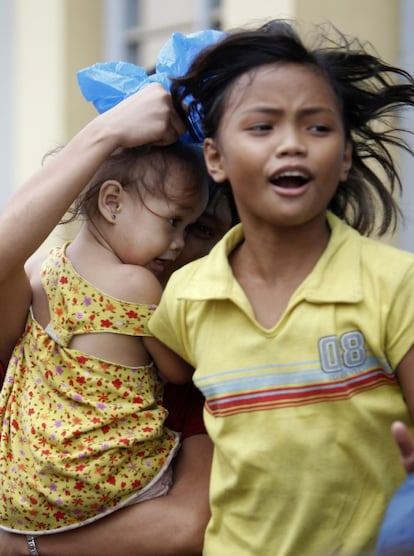 Una familia de evacuados a causa de las inundaciones que ha causado el tifón Hagupit en Manila. Entre 15 y 20 tifones visitan cada año Filipinas durante la temporada lluviosa, que empieza por lo general en junio y concluye en noviembre.
