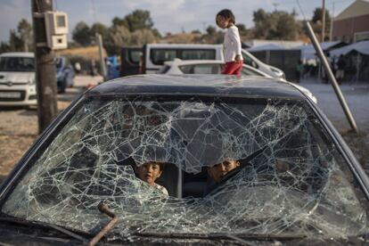 Varios niños afganos juegan en el interior de un automóvil abandonado cerca del nuevo campamento temporal de refugiados, en la isla de Lesbos (Grecia).