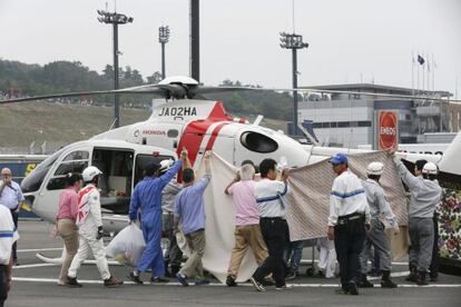 Trabajadores del circuito evitan que se vea c&oacute;mo De Angelis es evacuado del circuito en helic&oacute;ptero. 