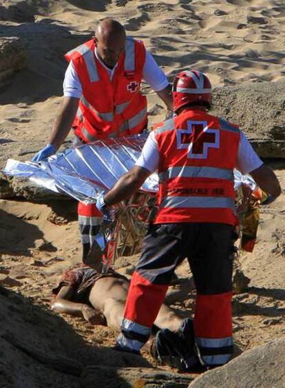 Miembros de Cruz Roja tapan el cuerpo del inmigrante hallado muerto ayer en Barbate.