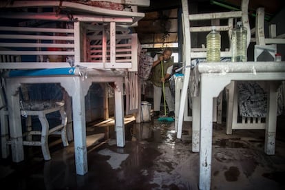 Una mujer barre el interior de su restaurante en Atizapán, en el Estado de México, afectado por las intensas lluvias de este lunes.