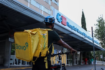 Un repartidor de Glovo espera frente al Hospital Universitario Gregorio Marañon, el 13 de julio de 2025.