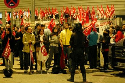 Un agente vigila a los integrantes de un piquete sindical.