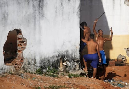 Detentos gesticulam para a polícia, que assiste de fora à movimentação em Alcaçuz, nesta terça-feira, 24.