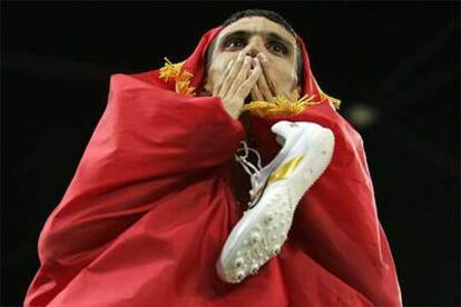 El marroquí Hicham El Guerruj celebra su victoria en la prueba de 5.000 metros envuelto en la bandera de su país en los JJ OO de Atenas 2004.
