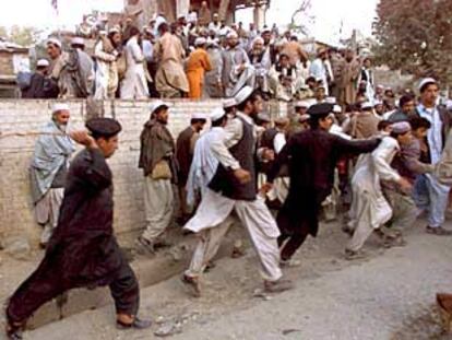 Policías de fronteras de Pakistán tratan de contener a un grupo personas congregadas en torno al puesto de Torkham.