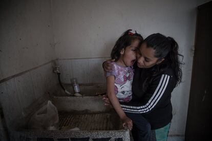 Valeria González y su hija Liz en el lavadero donde se asean con garrafones de agua. Liz sufre de discapacidad múltiple. Viven sin agua corriente en Ecatepec. Estado de México.