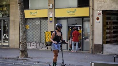 Una repartidora de Glovo, frente a un supermercado de la compañía de reparto en Barcelona.
