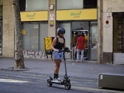 Una repartidora de Glovo, frente a un supermercado de la compañía de reparto en Barcelona.