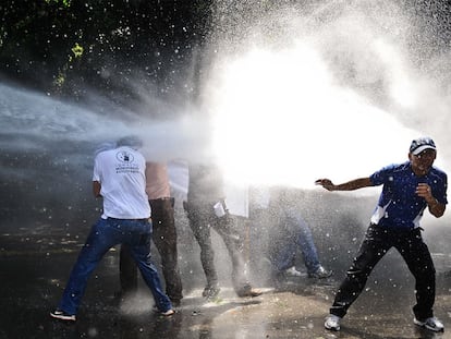 La policía venezolana intenta disolver con un cañón de agua a presión una manifestación de estudiantes contra la reforma de la legislación universitaria, el jueves en Caracas.