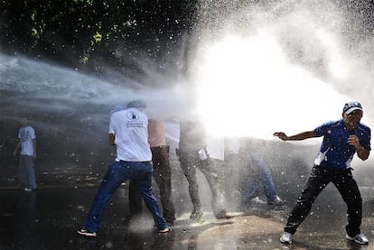 La policía venezolana intenta disolver con un cañón de agua a presión una manifestación de estudiantes contra la reforma de la legislación universitaria, el jueves en Caracas.