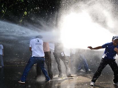 La policía venezolana intenta disolver con un cañón de agua a presión una manifestación de estudiantes contra la reforma de la legislación universitaria, el jueves en Caracas.