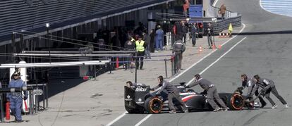 Los mecánicos del piloto mexicano Esteban Gutiérrez del equipo Sauber, introducen el monoplaza en su 'box'.