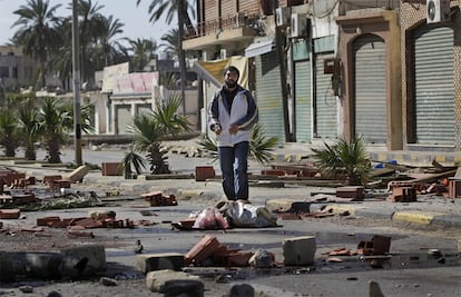 Un hombre camina entre los desperfectos que han dejado la batalla campal entre los opositores y los fieles a Gadafi. Trípoli se ha convertido en una ciudad fantasma. Todos tienen miedo. Nadie sale a la calle.