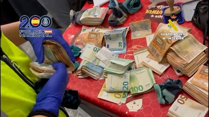 Fajos de billetes intervenidos durante los registros a las viviendas de un grupo criminal investigado por estafar con anuncios falsos de coches de segunda mano.