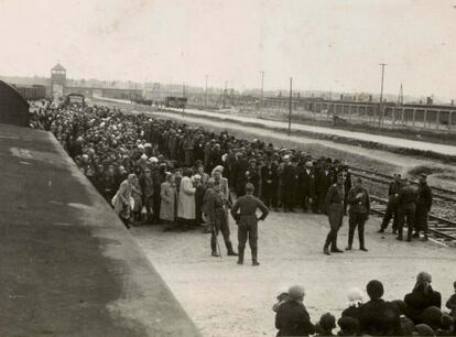 Deportados judíos esperando el proceso de selección. Al fondo puede verse la entrada de Birkenau, conocida en la actualidad como La puerta del suplicio.