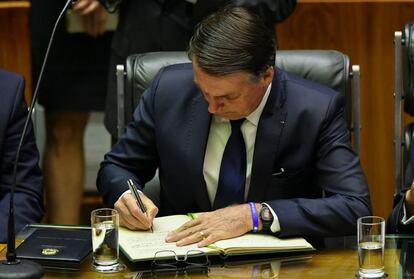 Jair Bolsonaro assina documento antes de fazer o juramento como presidente do Brasil.