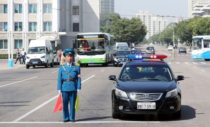 Un guardia de tráfico norcoreano permanece en guardia junto a un vehículo policial en una calle en Pionyang.