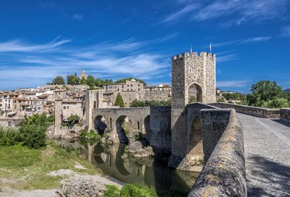 Entre los pueblos más fotogénicos de España, Besalú destaca con uno de los mejores conjuntos medievales de Cataluña. Está en la comarca de La Garrotxa, entre volcanes y hayedos que se tiñen de color en otoño para añadir un irresistible atractivo al que es por sí mismo un destino de incuestionable belleza. Su puente románico sobre el río Fluvià es la entrada al pueblo (en la foto). Una vez en el interior, los rincones para disparar la cámara se suceden: calles empedradas, casas de piedra, escudos de madera, un castillo, un ‘micvé’ (baño judío de purificación) o la iglesia del monasterio de Sant Pere.