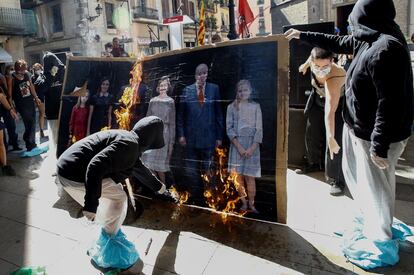 Varios jóvenes queman un retrato de la familia Real, hoy viernes, durante la manifestación convocada por la organización Arran en el centro de Barcelona con motivo de la Diada.