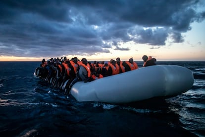 Migrantes y refugiados de diferentes nacionalidades africanas esperan ayuda a bordo de una embarcación de goma abarrotada en el mar Mediterráneo