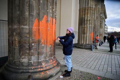 Dos activistas climáticos del grupo Última Generación pintan la fachada de la puerta de Brandenburgo, en Berlín.