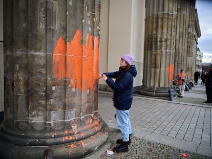 Dos activistas climáticos del grupo Última Generación pintan la fachada de la puerta de Brandenburgo, en Berlín.