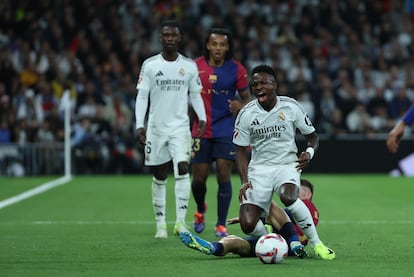 El delantero del Real Madrid Vinicius Jr. cae tras la entrada de Marc Casadó, del FC Barcelona.