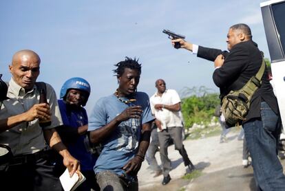 Un grupo de personas huye mientras el senador de Haití Jean Marie Ralph Fethiere dispara una pistola, en un incidente en el que resultó herido Chery Dieu-Nalio, fotógrafo de Associated Press. Fethiere se enfrentaba a partidarios de la oposición en la capital del país antillano, Puerto Príncipe.