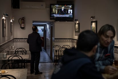 Clientes de un bar del centro de Barcelona siguen el discurso de investidura de Pedro Sanchez. 