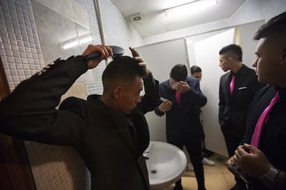 Los amigos de la quinceañera se atusan en el baño.