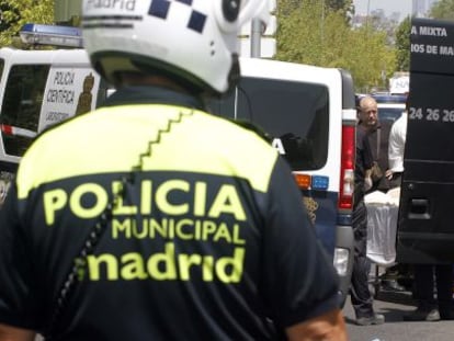 Dos policías observan el traslado de la mujer fallecida.